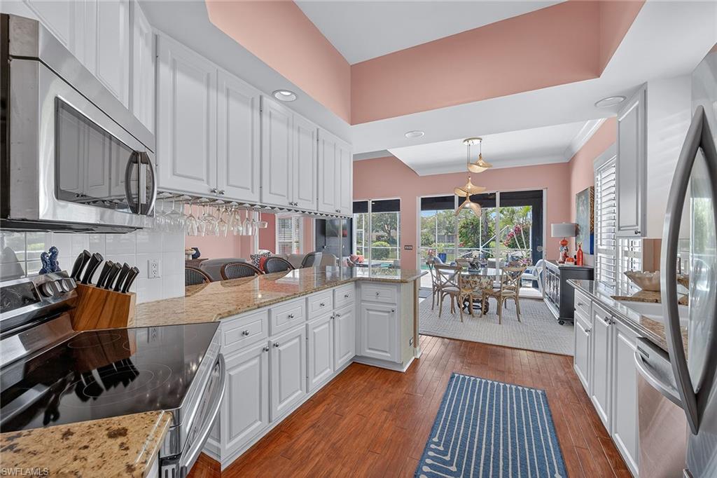 4013 Trinidad Way Naples, FL 34119 - Photo 11 of 35 a kitchen with stainless steel appliances granite countertop sink stove top oven and cabinets