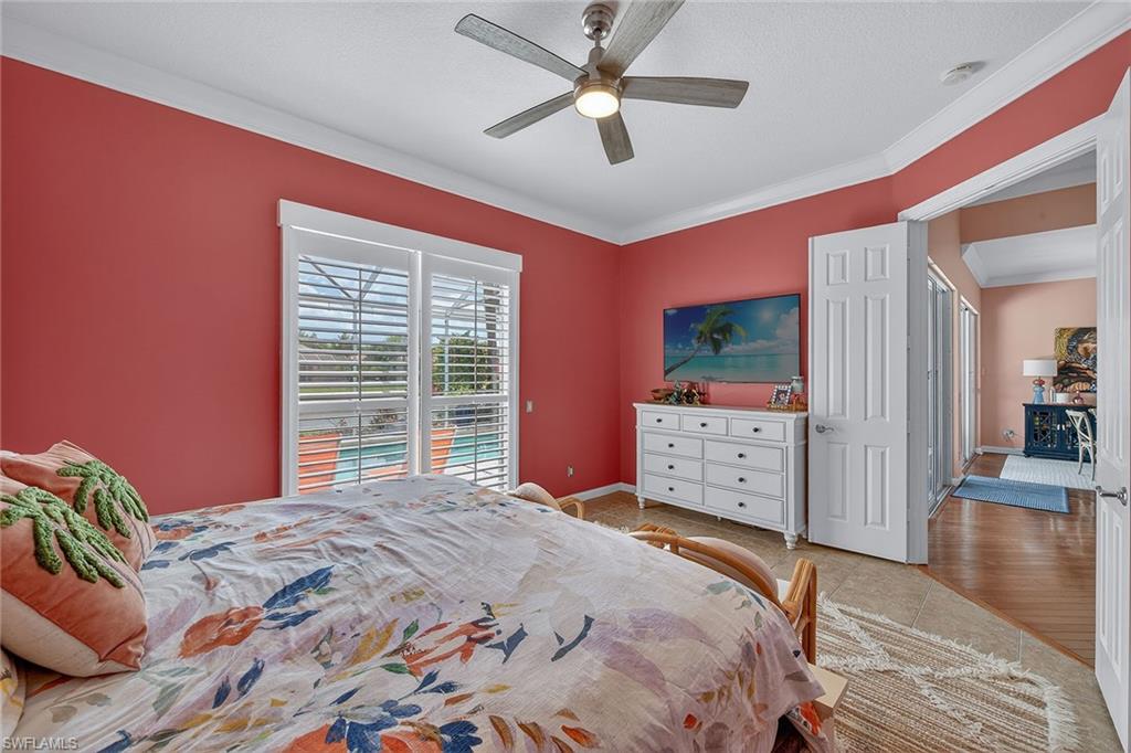 4013 Trinidad Way Naples, FL 34119 - Photo 14 of 35 a bedroom with a large bed and a chandelier