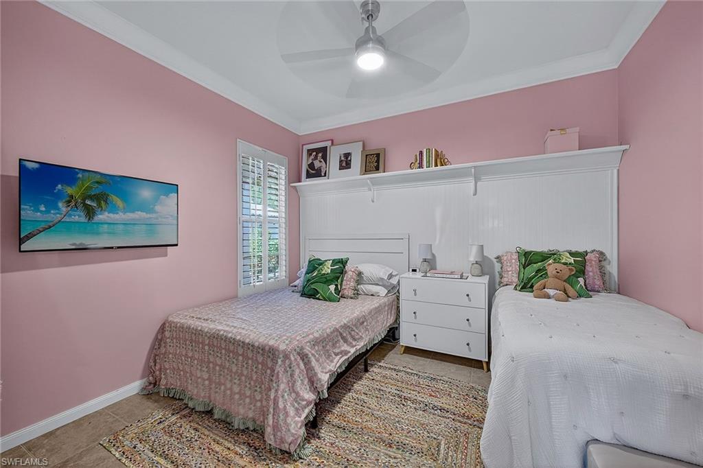 4013 Trinidad Way Naples, FL 34119 - Photo 19 of 35 a bedroom with a bed and a chandelier