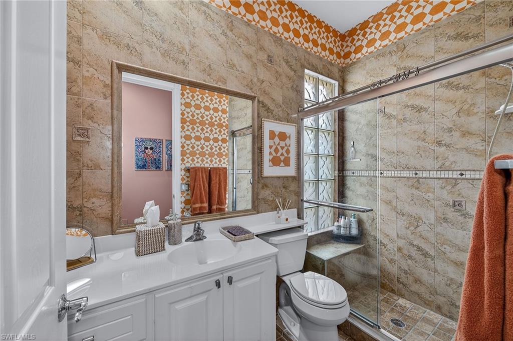 4013 Trinidad Way Naples, FL 34119 - Photo 20 of 35 a bathroom with a granite countertop sink a toilet and shower