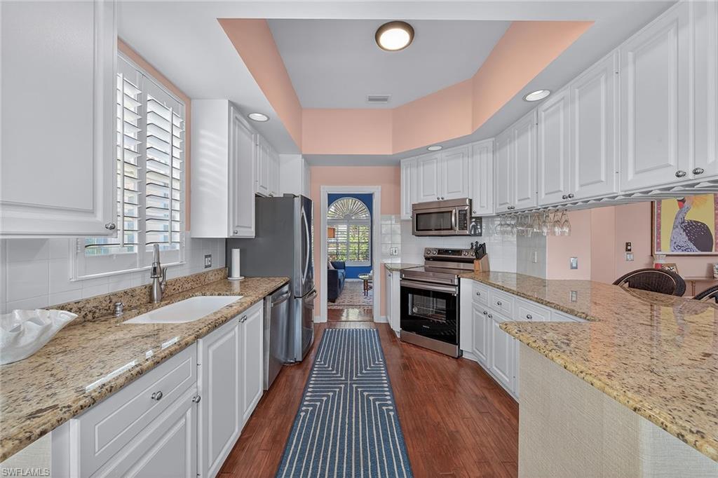 4013 Trinidad Way Naples, FL 34119 - Photo 10 of 35 a kitchen with stainless steel appliances granite countertop a stove a sink and a microwave