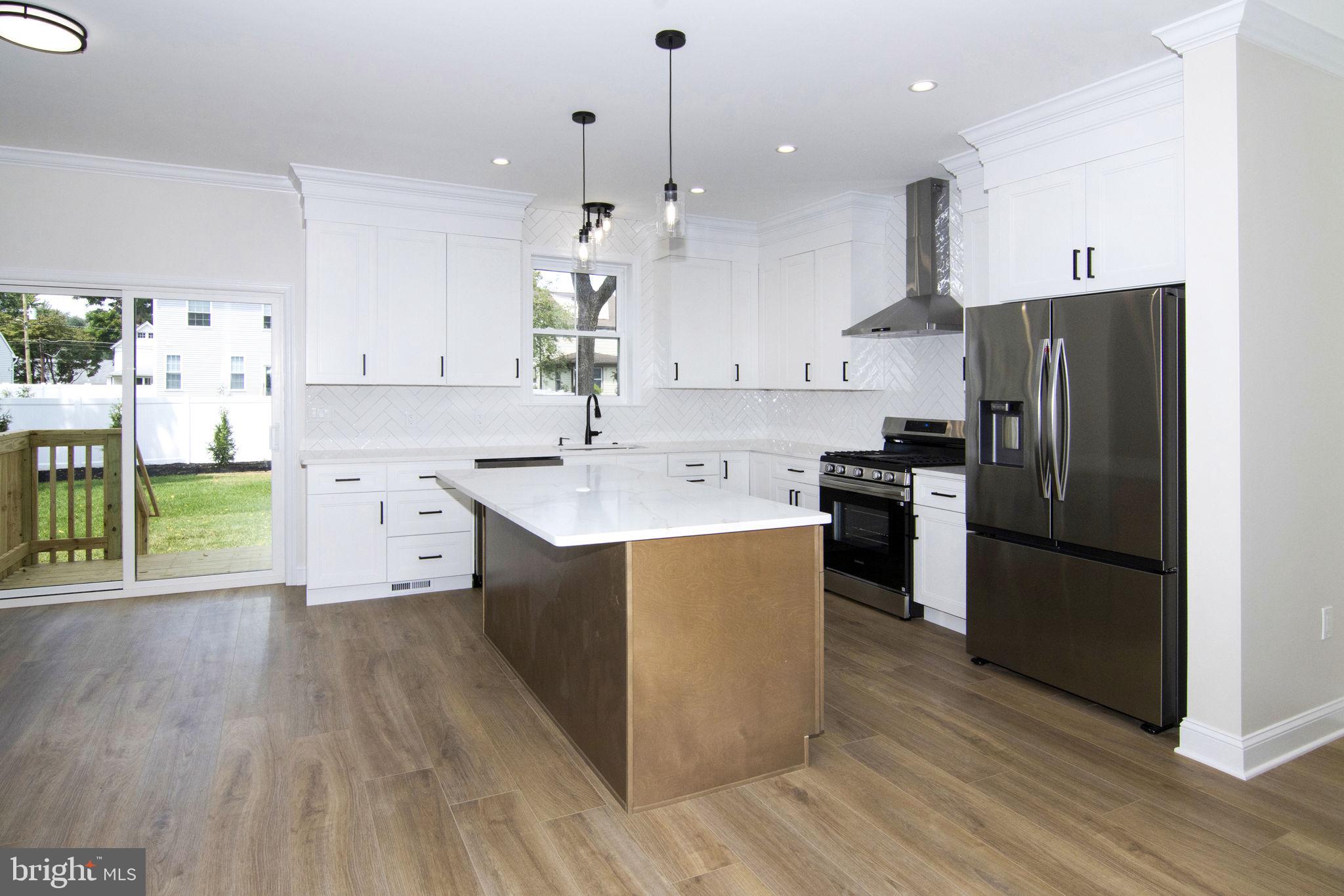 903 Mercer Street Cherry Hill, NJ 08002 - Photo 13 of 58 a kitchen with kitchen island a sink a counter top space stainless steel appliances and cabinets