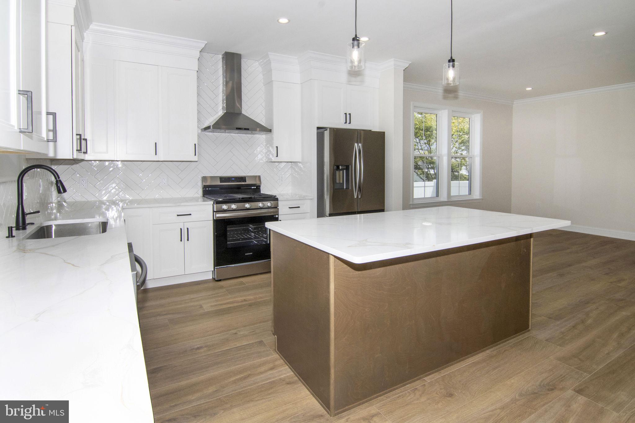 903 Mercer Street Cherry Hill, NJ 08002 - Photo 17 of 58 a kitchen with kitchen island a counter top space a sink stainless steel appliances and cabinets