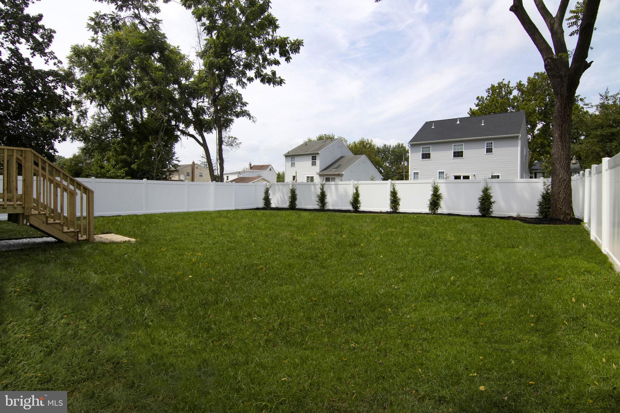 903 Mercer Street Cherry Hill, NJ 08002 - Photo 57 of 58 a view of a white house in front of a big yard with large trees and wooden fence