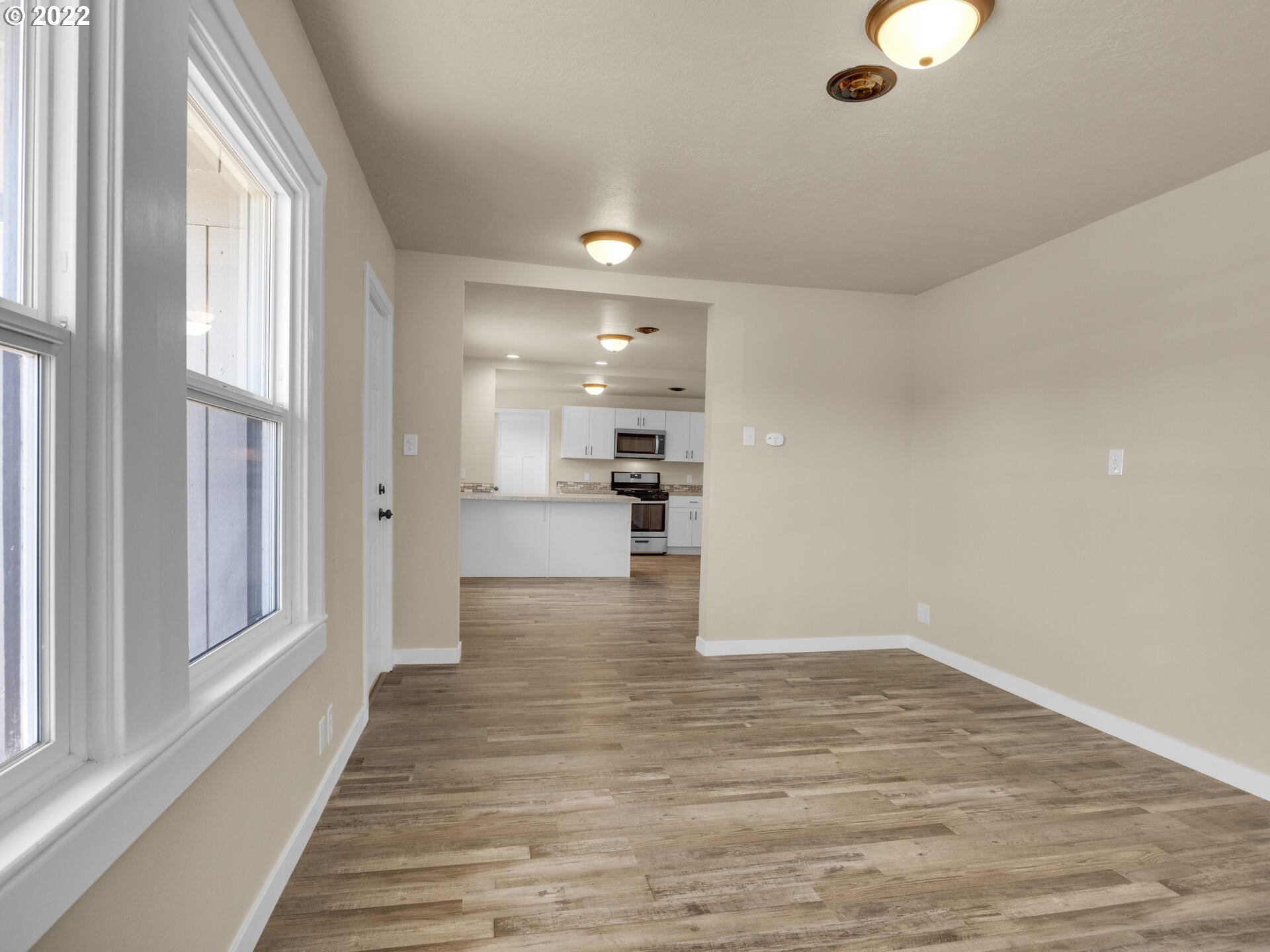 92356 E Road Astoria, OR 97103 - Photo 12 of 31 a view of a hallway with wooden floor and a kitchen