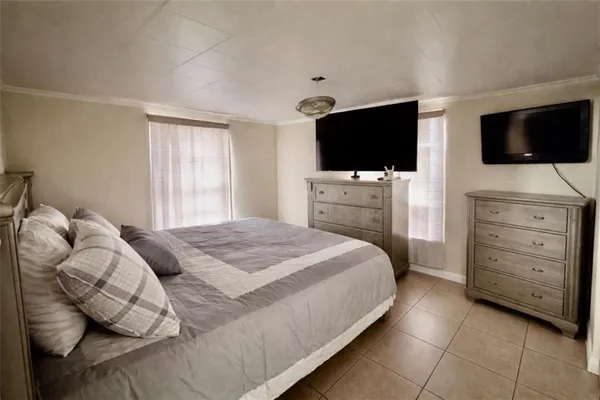 a bedroom with a bed a television and a couch