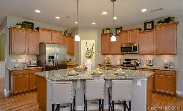 4282 Perth Road, Unit 315 Indian Land, SC 29707 - Photo 5 of 12 a kitchen with stainless steel appliances granite countertop a sink a stove a refrigerator cabinets and chairs