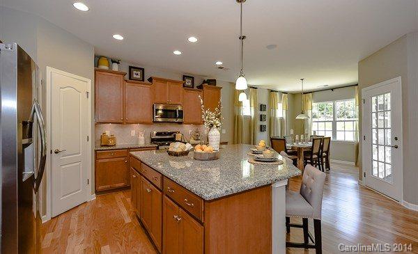 4282 Perth Road, Unit 315 Indian Land, SC 29707 - Photo 6 of 12 a kitchen with stainless steel appliances granite countertop a stove refrigerator and chairs