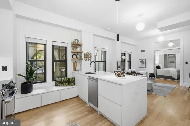 a kitchen with stainless steel appliances granite countertop a sink dishwasher a refrigerator and a stove with wooden floor