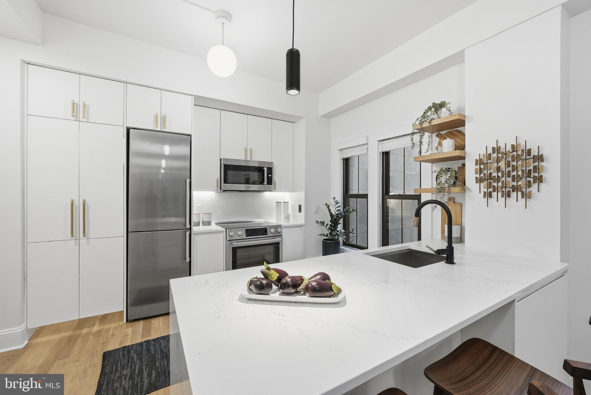 1613 Harvard Street Northwest, Unit 102 Washington, DC 20009 - Photo 6 of 21 a kitchen with stainless steel appliances granite countertop a sink dishwasher a refrigerator and a stove with wooden floor