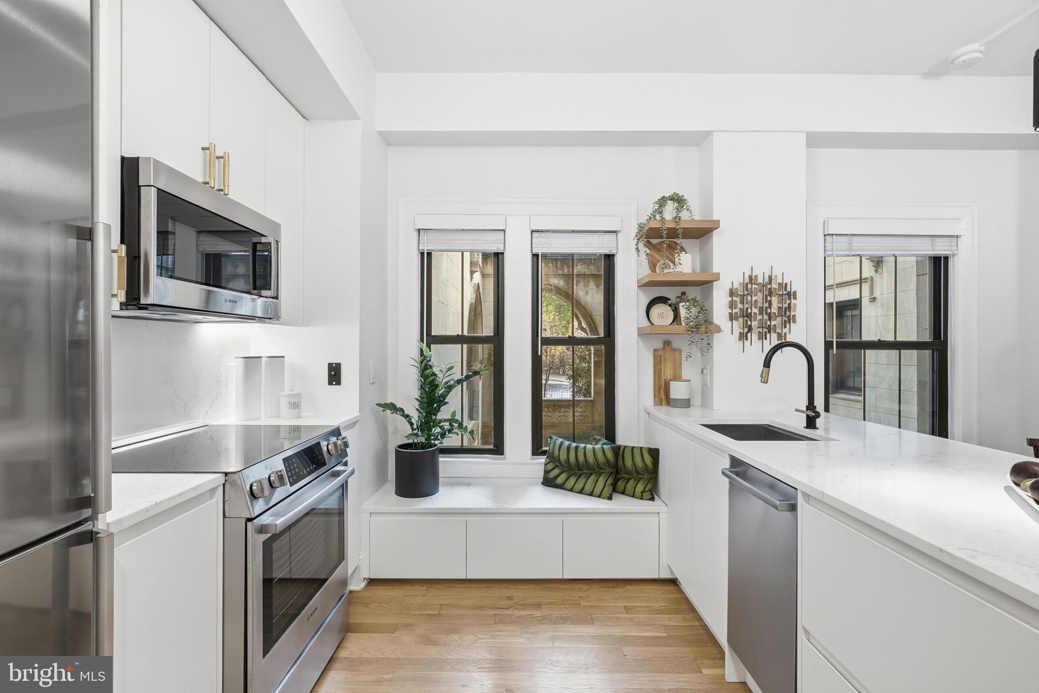 1613 Harvard Street Northwest, Unit 102 Washington, DC 20009 - Photo 8 of 21 a kitchen with stainless steel appliances granite countertop a stove and a sink
