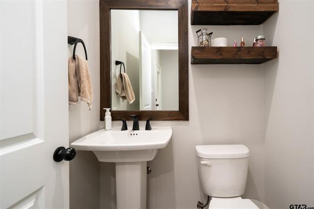 2151 Byrd Road Jacksonville, TX 75766 - Photo 16 of 40 a bathroom with a sink and mirror with toilet