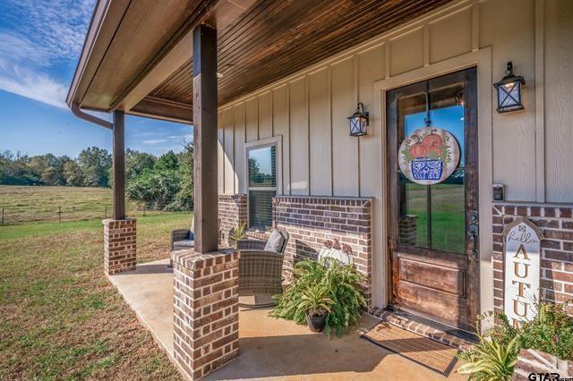 2151 Byrd Road Jacksonville, TX 75766 - Photo 3 of 40 Entrance to property featuring brick siding, a porch, and board and batten siding