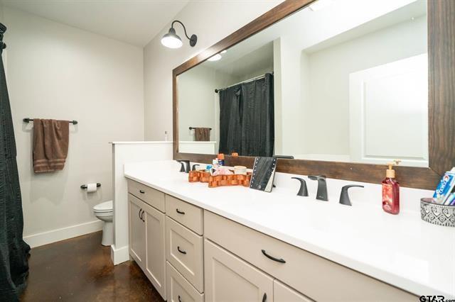 2151 Byrd Road Jacksonville, TX 75766 - Photo 31 of 40 Bathroom with double vanity, curtained shower, and concrete floors