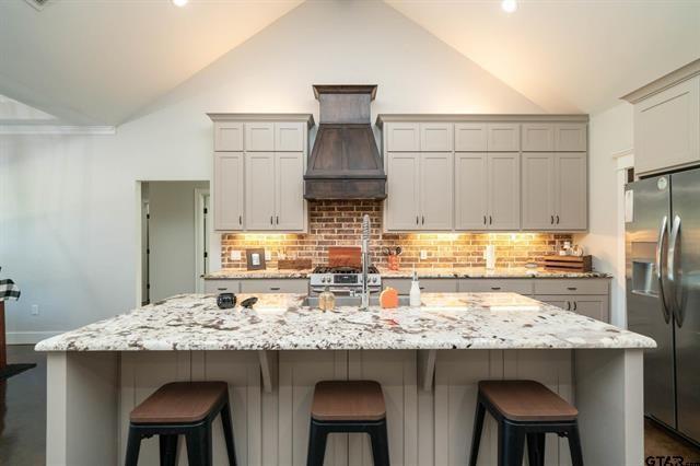 2151 Byrd Road Jacksonville, TX 75766 - Photo 10 of 40 a kitchen with stainless steel appliances granite countertop a table chairs stove and refrigerator