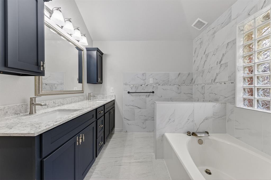 607 Rawlins Drive Lancaster, TX 75146 - Photo 18 of 26 a bathroom with a granite countertop bathtub sink vanity and mirror