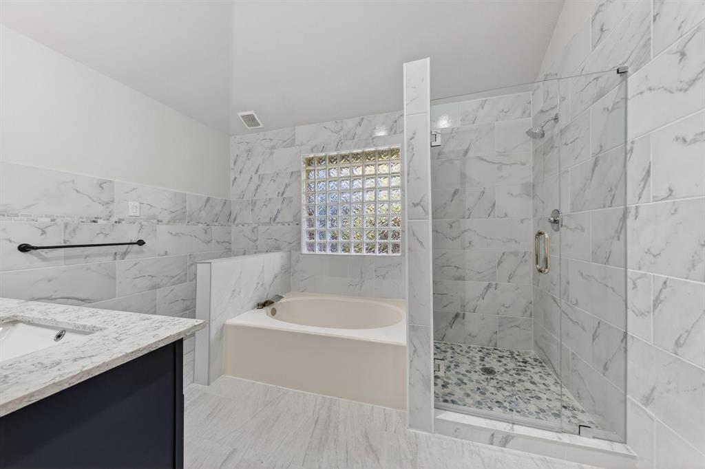 607 Rawlins Drive Lancaster, TX 75146 - Photo 20 of 26 a bathroom with a bathtub and a shower