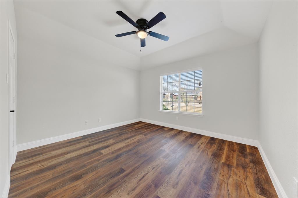 607 Rawlins Drive Lancaster, TX 75146 - Photo 23 of 26 an empty room with wooden floor ceiling fan and windows