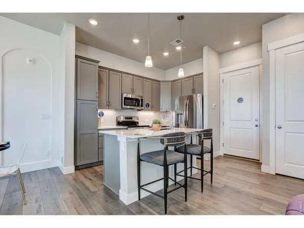 a kitchen with kitchen island wooden cabinets and refrigerator