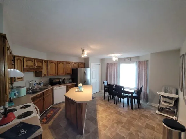 a kitchen with a dining table chairs and flat screen tv