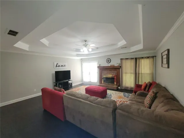 a living room with furniture a fireplace and a flat screen tv