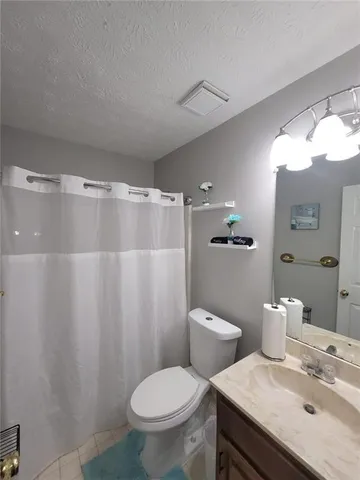 a bathroom with a granite countertop sink toilet and a mirror