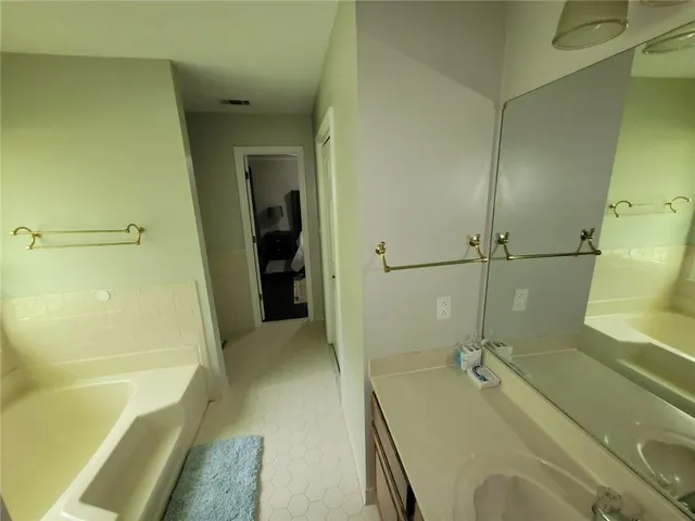a bathroom with a tub a sink and glass door