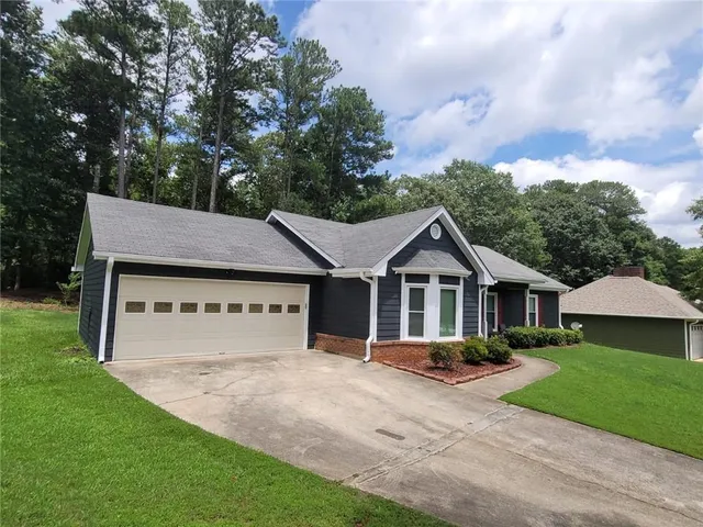 a view of a house with a yard and fence