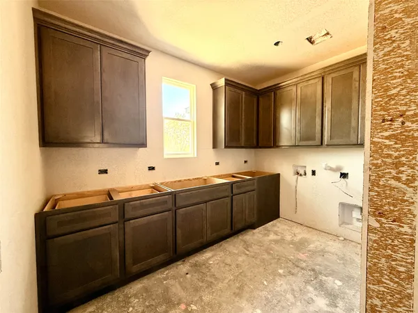 a kitchen with stainless steel appliances a refrigerator a stove a sink a microwave a refrigerator and white cabinets with wooden floor