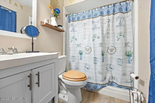 a bathroom with a sink a toilet and shower curtain