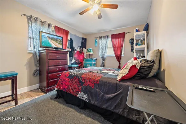 a bed room with a bed tv and a window