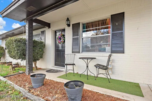 a front view of a house with garden and sitting area
