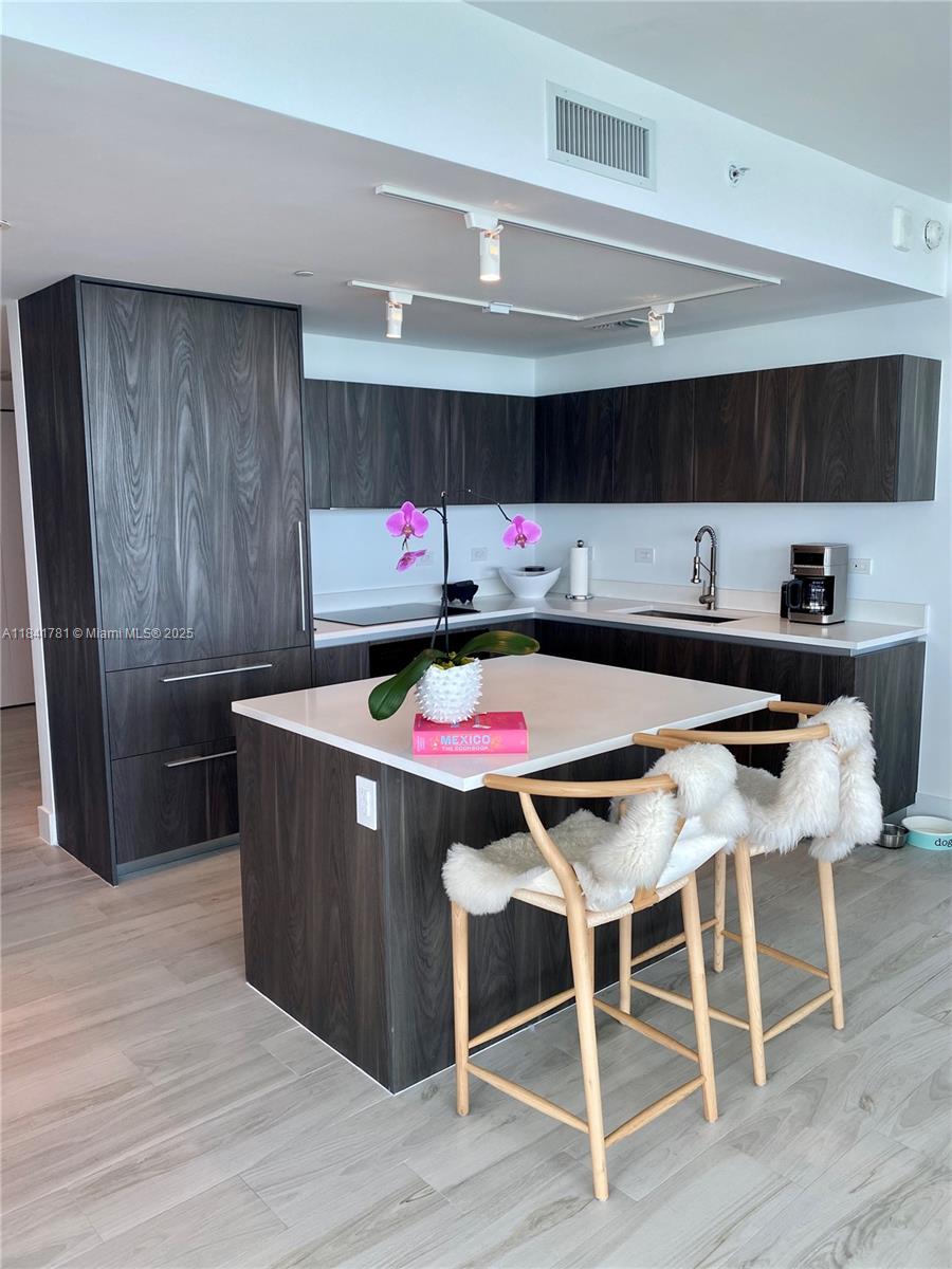 3131 Northeast 7th Avenue, Unit 2801 Miami, FL 33137 - Photo 11 of 47 a room with granite countertop lots of wooden furniture and wooden floor