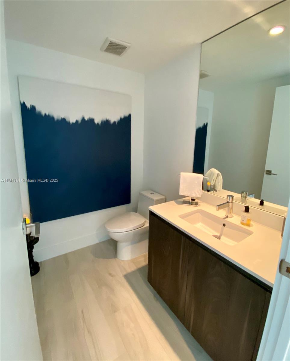 3131 Northeast 7th Avenue, Unit 2801 Miami, FL 33137 - Photo 26 of 47 a bathroom with a sink a toilet and a mirror