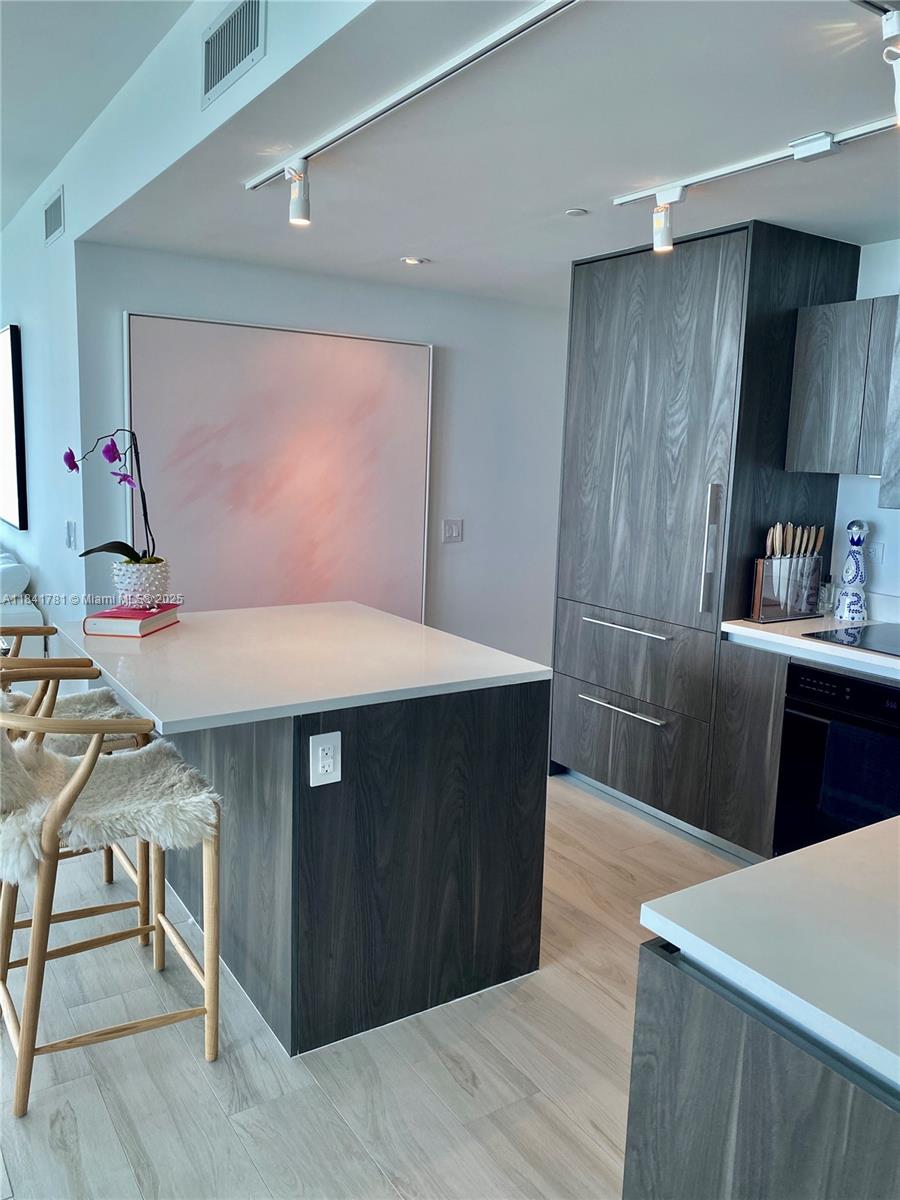 3131 Northeast 7th Avenue, Unit 2801 Miami, FL 33137 - Photo 10 of 47 a kitchen with a wooden table and chairs