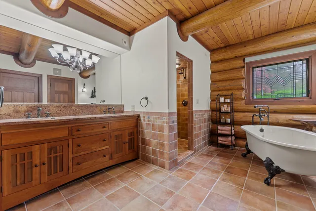 a spacious bathroom with a double vanity sink a mirror and a bathtub