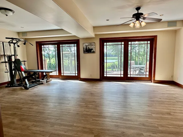 a view of an empty room with window and hardwood