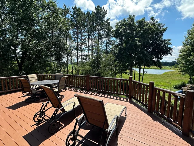 a view of a patio with table and chairs with wooden floor and fence