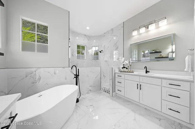 a spacious bathroom with a double vanity sink a mirror and a shower