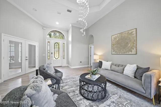 a living room with furniture a large window and a potted plant