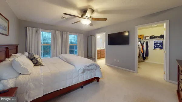 a large bed sitting in a bedroom next to a window