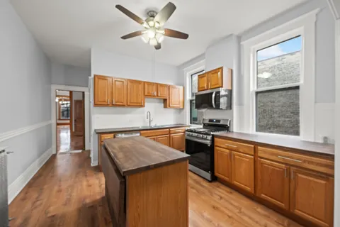 a kitchen with granite countertop a stove top oven sink and cabinets
