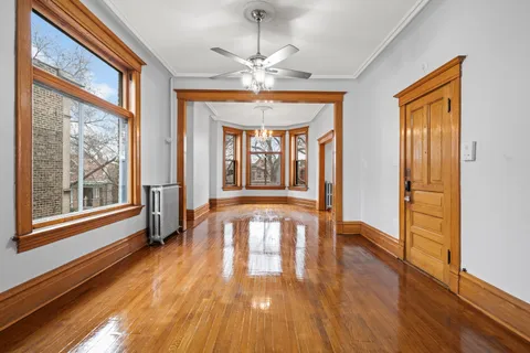 a view of a room with wooden floor fan and windows