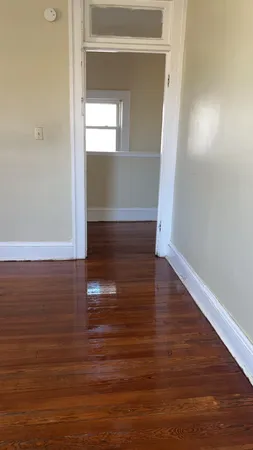 a view of empty room with wooden floor