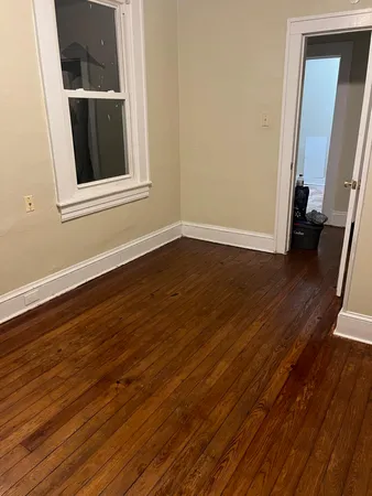 a view of a room with wooden floor and a window