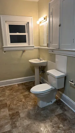 a bathroom with a toilet a sink and mirror