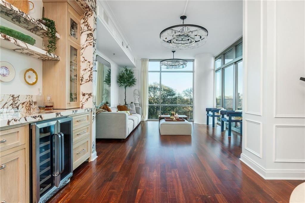 905 Juniper Street Northeast, Unit 705 Atlanta, GA 30309 - Photo 21 of 62 a living room with kitchen island granite countertop wooden floor a large window and stainless steel appliances