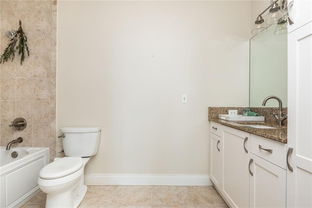 905 Juniper Street Northeast, Unit 705 Atlanta, GA 30309 - Photo 53 of 62 a bathroom with a granite countertop sink a toilet and a bathtub