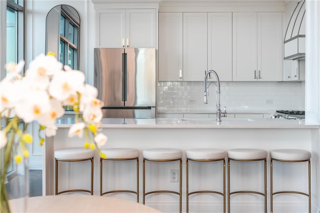 905 Juniper Street Northeast, Unit 705 Atlanta, GA 30309 - Photo 7 of 62 a kitchen with stainless steel appliances a table and chairs
