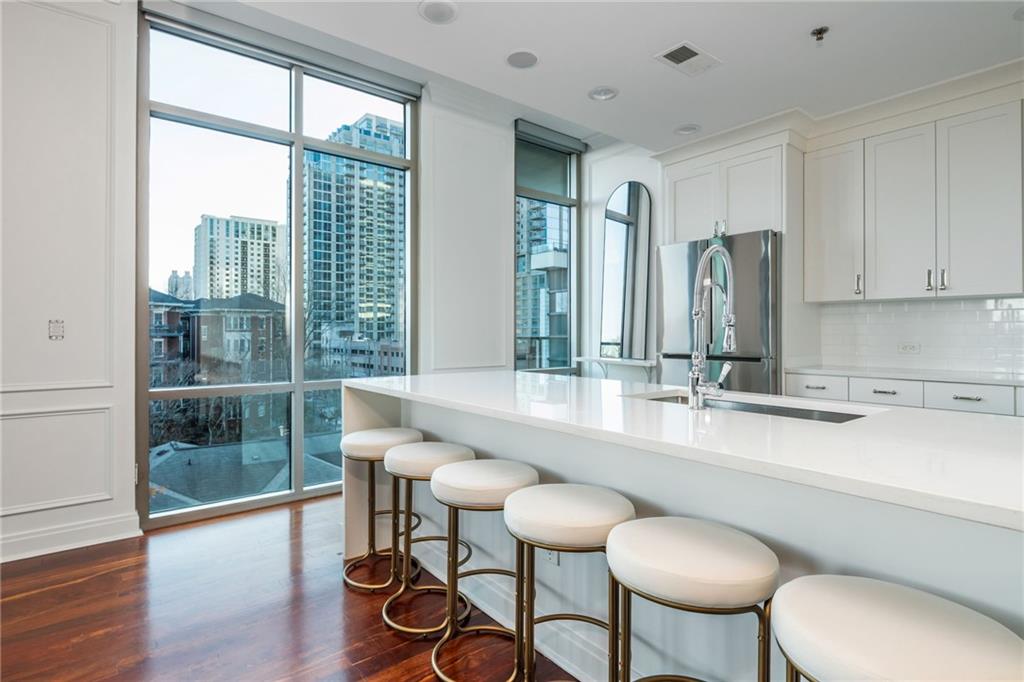 905 Juniper Street Northeast, Unit 705 Atlanta, GA 30309 - Photo 9 of 62 a kitchen with a table chairs sink and cabinets